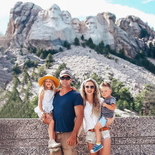 Family posing for picture in front of Mount Rushmore in South Dakota